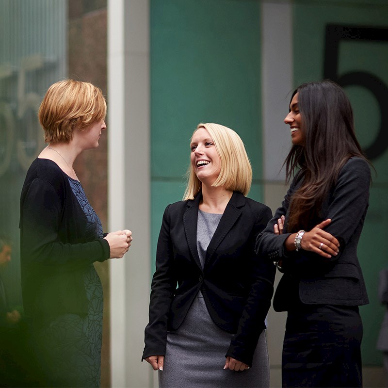 Three women talking in a hallway