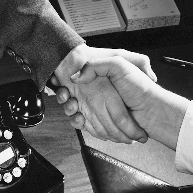 A black and white photo of a handshake